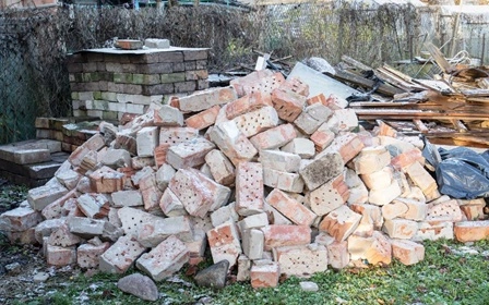 Heap of bricks, debris and junk waiting for Tommy's Junk Removal's construction waste removal.
